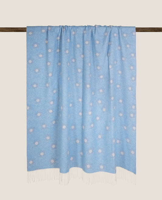 Plaid in soft bamboo realizzato con tecnica a navetta con tema floreale sui toni dell'azzurro arricchito da frange